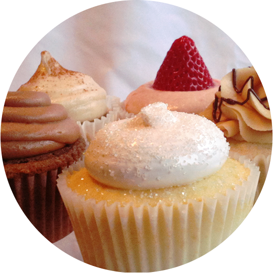 shown here are several delicious flavors: vanilla with italian merengue, milk chocolate with milk chocolate buttercream, strawberry with strawberry cream cheese, banana with peanut butter buttercream, and nice spice with cream cheese icing.